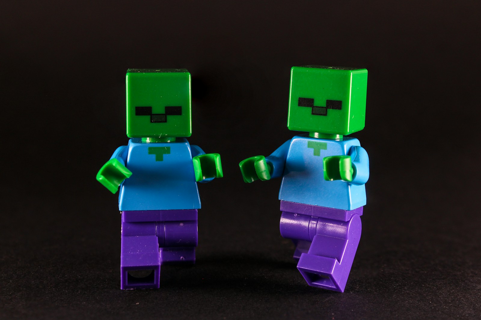 Two green-headed figures with blue shirts and purple pants.